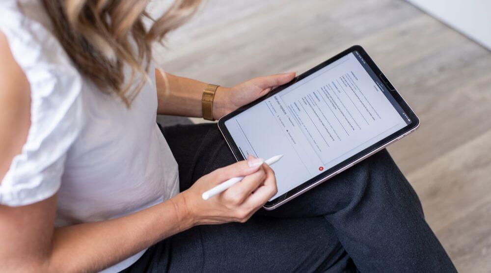 Image of women signing a document on a tablet computer