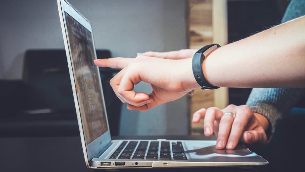 Hands pointing at laptop screen