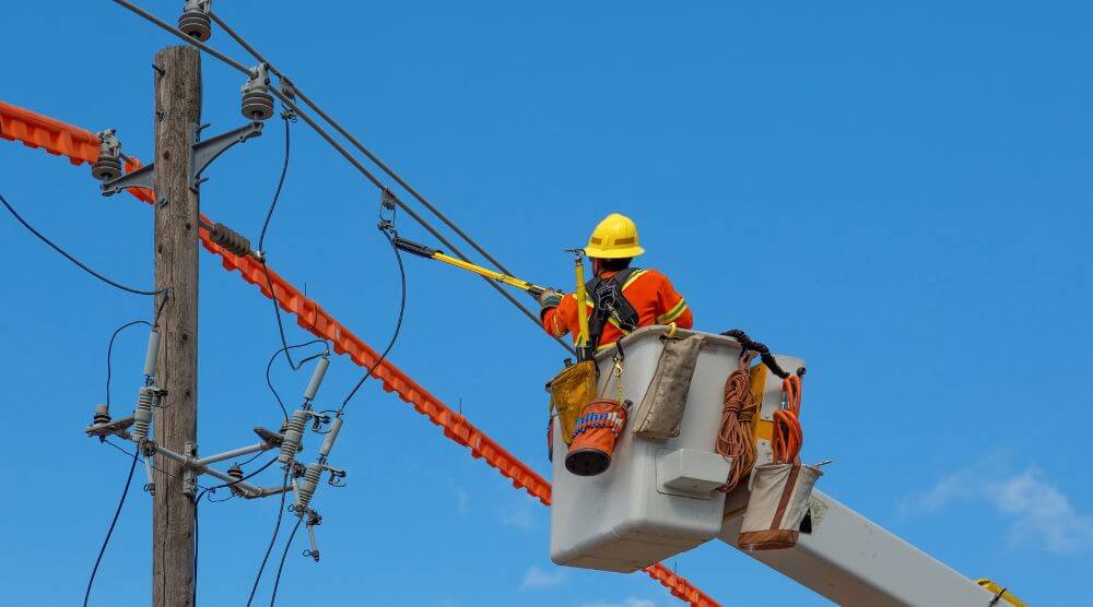 A person in hi vis attending to a power line